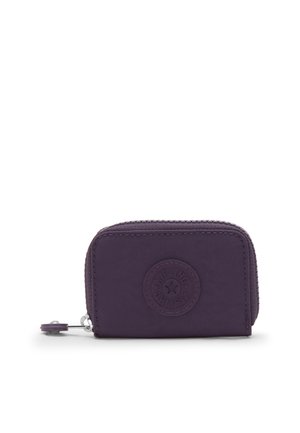 Pequeña cartera con cremallera de color púrpura oscuro, con bordes redondeados y un logotipo circular en relieve en el centro frontal, sobre un fondo blanco liso.