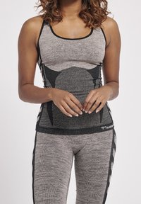 Graues Workout-Top und Leggings mit schwarzem Akzentmuster, strukturiertem Stoff und figurbetontem Design mit rundem Ausschnitt.