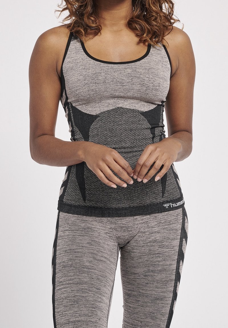 Graues Workout-Top und Leggings mit schwarzem Akzentmuster, strukturiertem Stoff und figurbetontem Design mit rundem Ausschnitt.