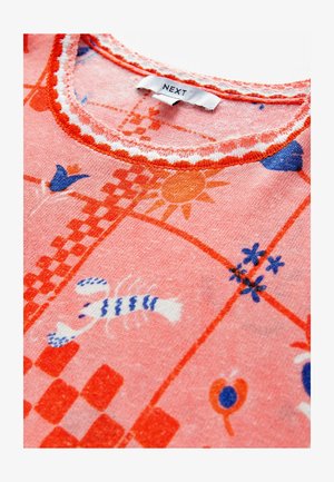 Pink cotton top featuring a checkerboard pattern, lobster, and floral designs in orange and blue. Contrast stitching on the neckline.