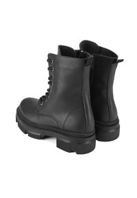 Schwarze Lederstiefeletten mit runder Zehenpartie, Schnürung vorne und strukturiertem Gummisohle. Mit Stickdetails und einem Reißverschluss ausgestattet.