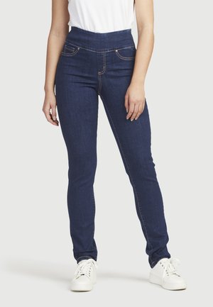 Höga mörkblå denimjeans med orange sömnad, två främre fickor och smal passform, matchade med vita sneakers.