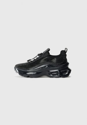 Zapatilla deportiva negra con parte superior tejida, suela de goma suave, notable amortiguación de aire y sistema de cordones elásticos para un ajuste seguro.