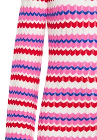 Pulover tricotat cu dungi zigzag în roșu, roz, alb și albastru. Mâneci lungi, țesătură texturată cu un design cu nervuri.