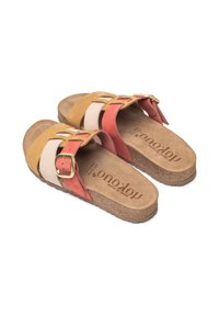 Tan, witte en koraalkleurige suède slide sandalen met een verstelbare gesp, kurken voetbed en uitsparingen in de banden. Textuur op de zool voor grip.
