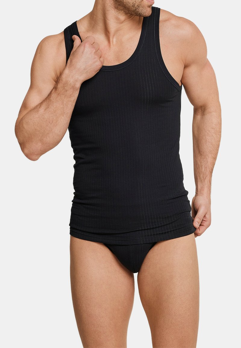 Top a canotta nero a coste con spalline larghe, design aderente e slip coordinato. Materiale in cotone con dettagli in texture orizzontale su tutta la superficie.