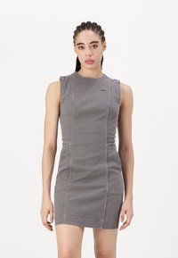 Grå utenermet denimkjole med tettsittende design, med sømmedetaljer og små skulderstropper. Glatt tekstur, lengde over kneet.