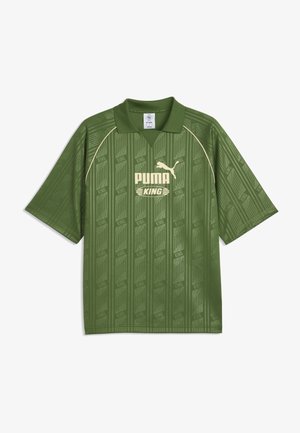 Zielona koszula Puma King z krótkim rękawem, kołnierzykiem, subtelnym paskowanym wzorem oraz jasnobeżowym logo i napisem Puma z przodu.