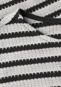 Tissu tricoté à rayures noires et blanches avec un tissage lâche, comportant des rayures épaisses et fines alternées et un col arrondi.
