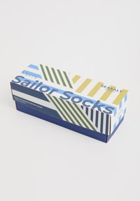 Sockenschachtel für Matrosen mit einem geometrischen Design in blauen, grünen und gelben Streifen. Blaue Basis und Text, der Material und Größe auf der Vorderseite angibt.