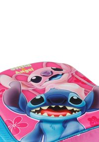 Mochila rosa con un gráfico de dos personajes de dibujos animados, Stitch y Angel. Material suave con colores vibrantes y patrones florales.
