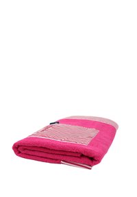 Toalla rosa con textura suave, que presenta un acento de tela a rayas y un bolsillo de parche. Doblada, mostrando el contraste de color y el diseño.