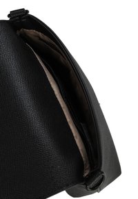 Černá texturovaná kožená kabelka se zipovým uzávěrem a prostorným interiérem s jemnou textilní podšívkou. Zahrnuté diskrétní kovové akcenty.