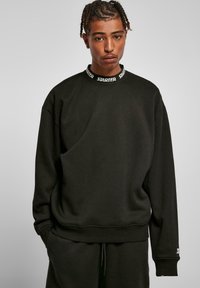 Sort sweatshirt med rund halsudskæring og elastiske manchetter. Har en mærket krave og en afslappet pasform. Blød tekstur, enkelt design.