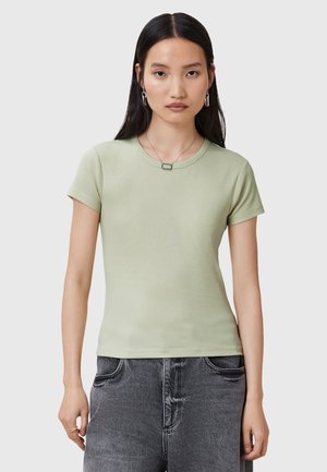 T-shirt fitted verde chiaro con maniche corte, scollatura rotonda e texture liscia. Indossato con pantaloni a vita alta grigi scuri.