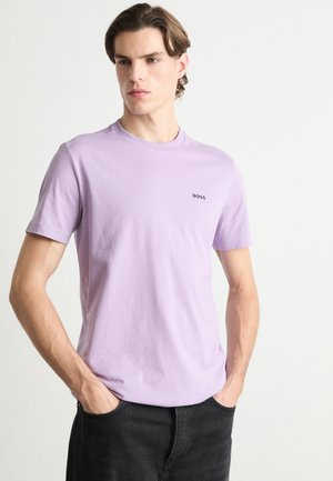 T-shirt mauve clair à manches courtes en tissu doux, avec un col rond et un petit logo noir "BOSS" sur la poitrine.
