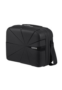 Étui rigide noir avec un design angulaire texturé. Il dispose d'une fermeture éclair et d'une bandoulière ajustable pour un transport facile.