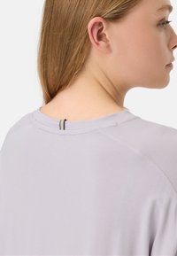 Lichtpaarse t-shirt met een ronde halslijn en een open detail aan de achterkant. Gemaakt van zacht, glad materiaal met zichtbare naden.