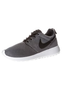 Black and white sneaker with a mesh upper, round toe, and a white rubber sole. Features black Nike logo and lace-up design.