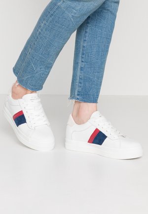 Białe sneakersy z granatowymi i czerwonymi zamszowymi paskami po bokach, sznurowana konstrukcja oraz górna część z gładkiej skóry. Teksturowana gumowa podeszwa. Styl casual.