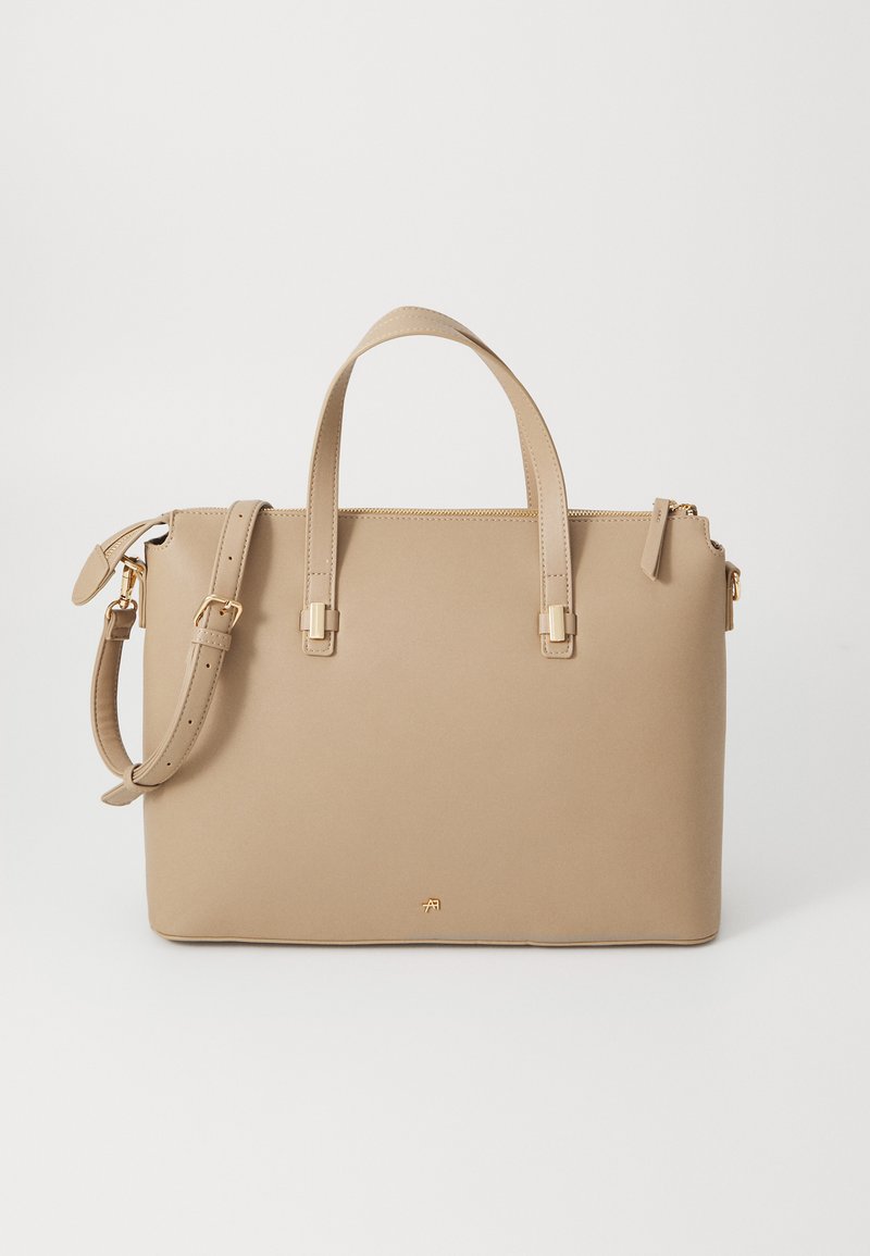 Beige leather handbag with dual handles, detachable shoulder strap, gold hardware accents, and a zip closure. Smooth texture and structured shape.