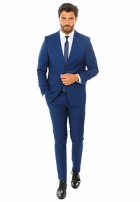 Abito blu su misura con giacca strutturata, pantaloni slim-fit e camicia bianca. Scarpe lucidate nere, con una cravatta semplice e design elegante.
