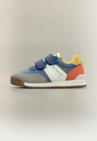 Αθλητικό παπούτσι σε μπλε και γκρι χρώμα με λουράκια Velcro, λευκές λεπτομέρειες και πορτοκαλί και κίτρινες αποχρώσεις. Λαστιχένια σόλα, επάνω μέρος με πολυυφή σχεδίαση.