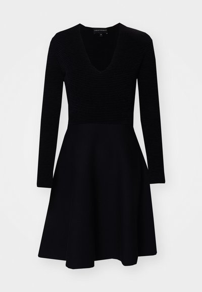 Vestido preto com corpete de mangas longas caneladas, decote em V profundo e saia rodada. Feito de um tecido suave e macio. Design simples.