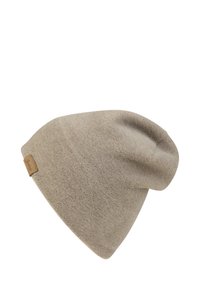 Light brown beanie made of soft, textured material with a slouchy design; features a small, branded leather tag on the side.