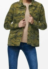 Jakke med camouflagemønster i grønne nuancer, lavet af slidstærkt materiale. Har knaplukning foran, to brystlommer og en krave.