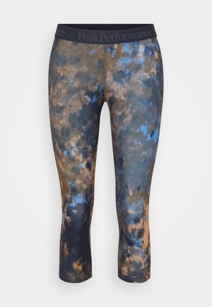 Three-quarter length leggings in a multicolored pattern featuring blue, brown, and beige hues. Made of stretchy fabric with a black waistband.