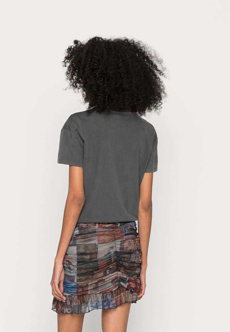 Szary bawełniany t-shirt z krótkim rękawem i okrągłym dekoltem, w połączeniu z wielokolorową, wzorzystą mini spódnicą z marszczeniem i falbaniastym wykończeniem.