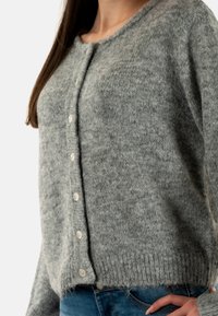 Cardigan de lana gris con escote redondeado, tejido texturizado y botones de perla en el frente. El dobladillo es acanalado para añadir detalle.