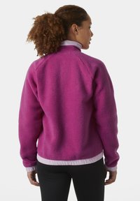 Fleecejack in levendig roze, met een staande kraag, elastische manchetten en onderste zoom met witte accenten. Getextureerd, warm materiaal.