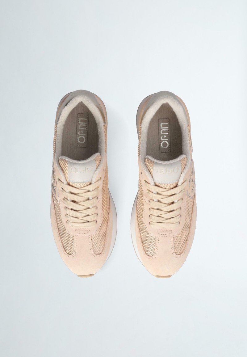 Beżowe buty sportowe z zamszową i siateczkową cholewą, okrągłym noskiem, teksturowanymi sznurowadłami oraz amortyzowaną podeszwą z wytłoczonym logo.