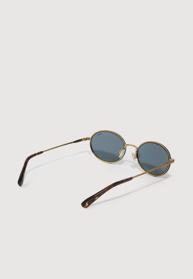 Lunettes de soleil rondes avec des verres teintés bleus et une monture en métal doré. Branches en motif écaille et plaquettes de nez réglables pour un meilleur ajustement.