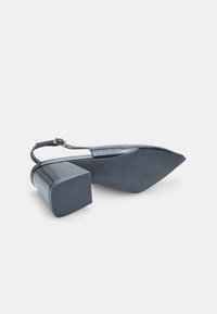Black patent leather high-heeled shoe with a pointed toe, block heel, and ankle strap. Smooth texture with a solid, shiny finish.