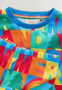 Värikkäät lasten pyjamat, joissa on rohkeita kirjaimia ja muotoja sinisessä, oranssissa, keltaisessa ja vihreässä puuvillakankaassa. Lyhyet hihat ja kuminauhavyötärö.