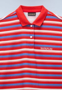Κόκκινο, μπλε και λευκό οριζόντια ριγέ πόλο πουκάμισο με κόκκινο γιακά, δύο λευκά κουμπιά και κεντημένο λογότυπο "NAPAPIJRI" στο στήθος.