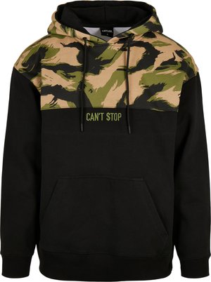 Sweat à capuche avec un corps noir et un motif de camouflage vert et beige sur le dessus. L'avant affiche le texte "CAN'T STOP" en vert.