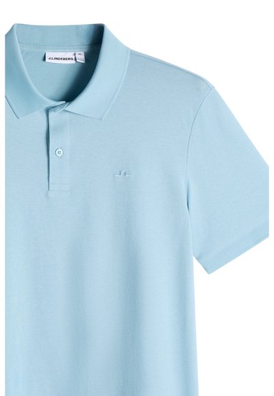 Polo a maniche corte azzurro chiaro con colletto, due bottoni e piccolo logo ricamato sul petto a sinistra.