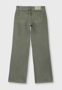 Jean large vert olive avec poches arrière et étiquette de marque beige à la ceinture, vu de dos.