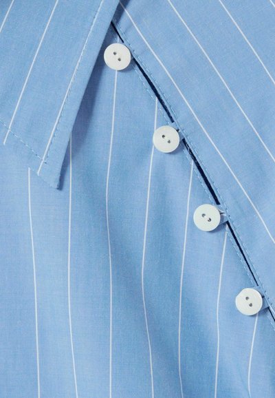 Camisa de rayas azul claro con rayas verticales blancas, un cuello puntiagudo y botones redondos blancos a lo largo de la tapeta delantera.