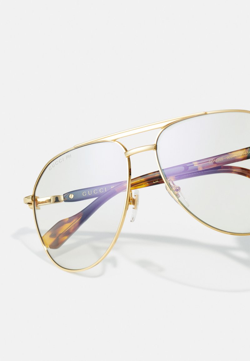 Gucci Sonnenbrillen mit goldenen Metallrahmen, verspiegelten Gläsern und lila-gestreiften Bügeln. Einstellbare Nasenpads inklusive.