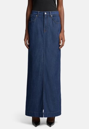 Mørkeblå denim maxiskjørt med rett snitt, frontslitt, beltehanker og fem lommer. Kombinert med svarte høyhælte sko.