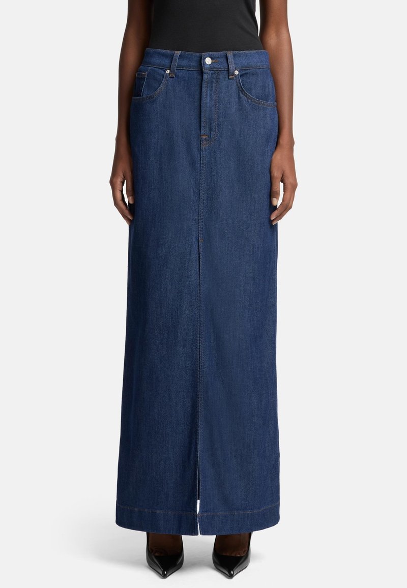 Mørkeblå denim maxiskjørt med rett snitt, frontslitt, beltehanker og fem lommer. Kombinert med svarte høyhælte sko.