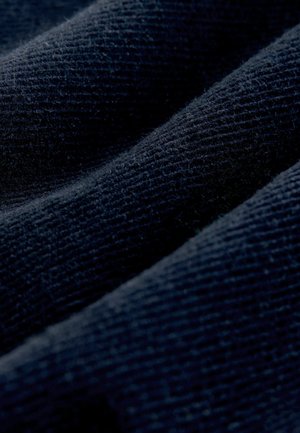 Tumes tekstureeritud kangas ribadega mustriga, omades pehmet, kudumise välimust. Materjal näitab kergeid erinevusi kudumise tiheduses.