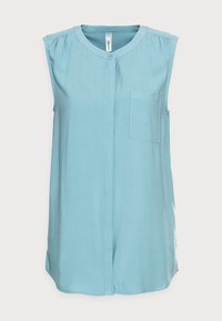 Blouse sans manches bleu clair en tissu doux, avec fermeture boutonnée à l'avant, col et poche poitrine. Texture lisse avec fentes latérales.