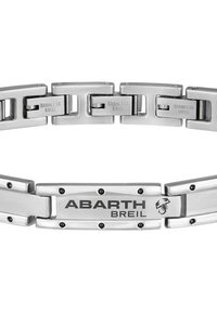 Ruostumattomasta teräksestä valmistettu rannekoru, jossa on toisiinsa kytkeytyviä lenkkejä. Keskellä on suorakulmainen solki, johon on kaiverrettu "ABARTH BREIL" sekä logoaksentteja.