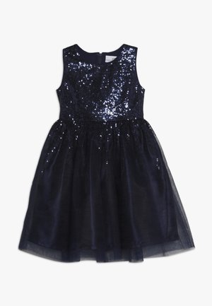 Marineblauwe jurk met een pailletten bovenstuk en een tule rok. Heeft een mouwloos ontwerp en een ritssluiting aan de achterkant.